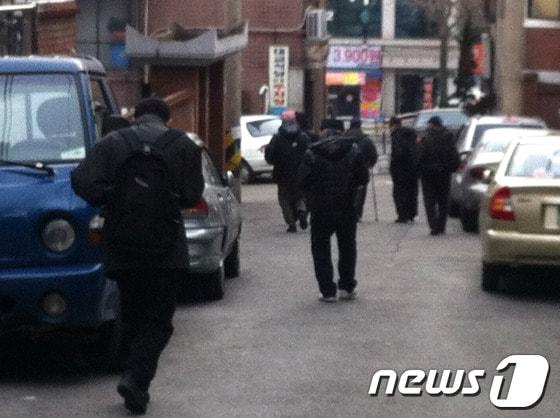 본문 이미지 - 노숙인들이 이른 아침부터 '짤짤이'를 받기 위해 걸음을 재촉하고 있다.© News1 