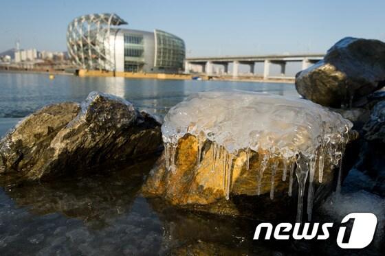 본문 이미지 - 서울 최저기온이 영하 10도 까지 떨어지는 등 한파가 이어진 5일 오후 서울 한강시민공원 반포지구 바위에 매달린 고드름 뒤편으로 세빛둥둥섬이 보이고 있다. 한강의 인공섬인 &#39;세빛둥둥섬&#39;은 구조설계가 변경됐지만 안전 문제로 당국의 허가를 받지 못하고 4개월째 방치되고 있다. 구조변경에 드는 공사비는 기존 960여억 원 외에 추가로 60억 원이 필요한 것으로 알려졌다. © News1 유승관 기자