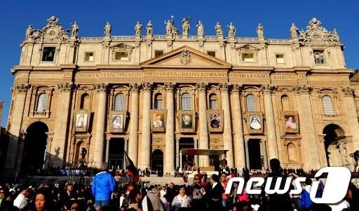 본문 이미지 - 21일 바티칸의 성 베드로 대성당 건물 외벽에 7명 성인 초상화가 걸려 있다. © AFP=News1  