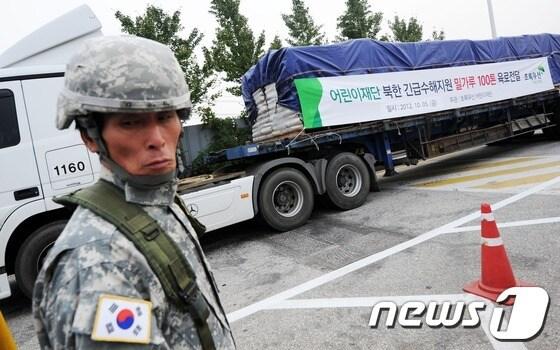 본문 이미지 - 5일 오전 경기도 파주시 통일대교에서 국내 55개 인도적 대북 지원단체 협의체인 대북협력민간단체협의회(북민협)의 대북 수해지원용 밀가루 500톤을 실은 트럭들이 임진강을 건너 북녘으로 향하고 있다. 북민협과 민화협은 북한 평안남도의 수재민들을 돕기 위해 1차로 밀가루 500톤(2억 6천만 원 상당)을 개성 육로를 통해 북한에 지원했다. 2012.10.5/뉴스1 © News1 오대일 기자