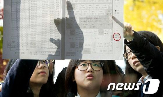 본문 이미지 - 지난해 대학수학능력시험 예비소집이 실시된 서울의 한 여고에서 수험생들이 시험실별 수험생 배치표를 확인하고 있다. 뉴스1 © News1 이명근 기자