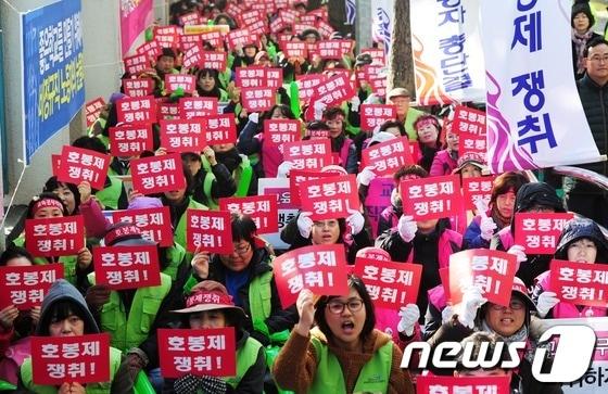 본문 이미지 - 전국학교비정규직 연대회의가 총파업에 돌입한 9일 오전 서울 도렴동 정부중앙청사 후문에서 학교 비정규직 노동자들이 호봉제 도입, 교육감의 직접 고용 등을 요구하는 구호를 외치고 있다. © News1 이정선 기자