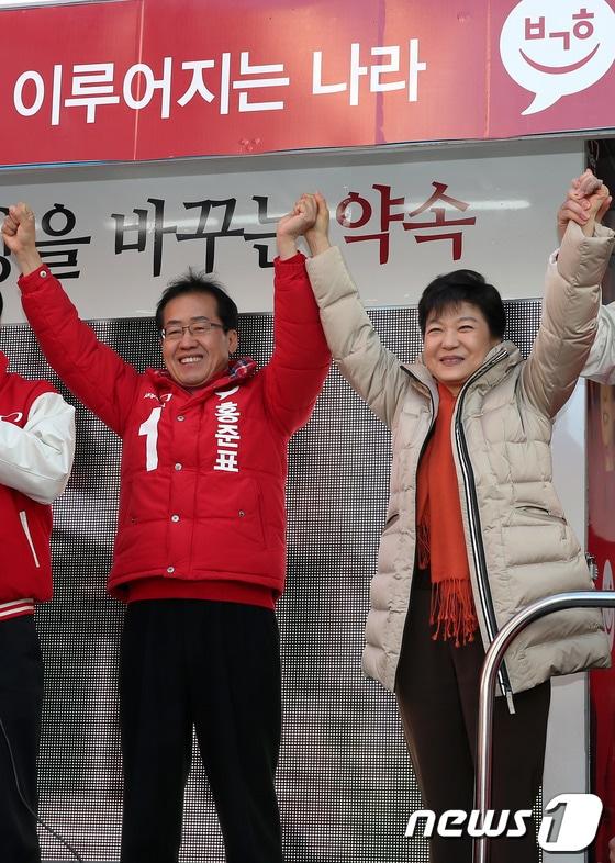 본문 이미지 - 2012년 12월 1일 당시 박근혜 새누리당 대선후보가 경남 김해시 동상동 재래시장을 방문, 유세차량에 올라 압도적 지지를 호소한 후 홍준표 경남도지사 후보와 함께 손을 맞잡아 들고 있다. 2012.12.01 ⓒ 뉴스1 DB