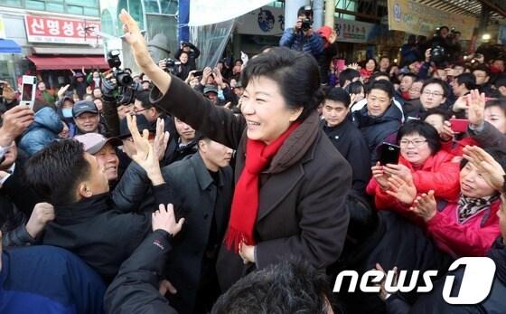 본문 이미지 - 박근혜 새누리당 대통령후보가 11일 제주도 제주시 동문재래시장에서 상인 및 지지자를 향해 손을 들어 인사하고 있다. 박후보는 갈치 3마리를 5만원에 샀다.2012.12.11/뉴스1 © News1 이종덕 기자