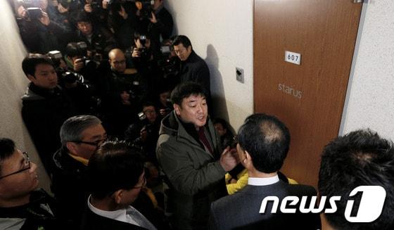 본문 이미지 - 민주통합당이 국가정보원 직원의 대선 개입 의혹을 제기해 파문이 일고 있는 가운데 12일 국정원 여직원 김모(28ㆍ여)씨가 거주하는 서울 강남구 역삼동의 한 오피스텔에서 국정원 관계자(뒷모습 보이는 이)가 당직자들과 언쟁을 벌이고 있다.  2012.12.12/뉴스1