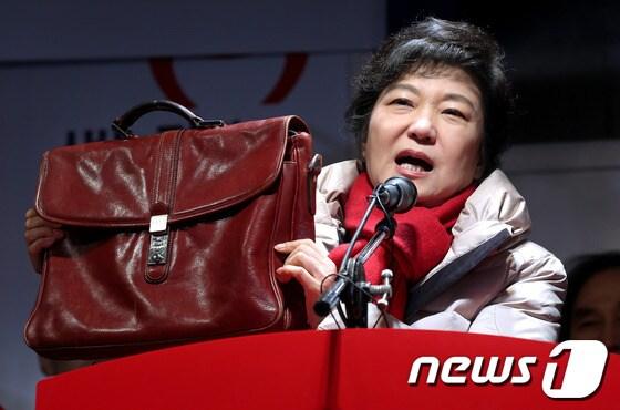 본문 이미지 - 박근혜 새누리당 대선후보가 12일 오후 대구광역시 중구 동성로에서 유세 차량에 올라 야당 의원이 아이패드 가방이라고 의혹을 제기했던 자신의 가방을 들고 10년 넘게 사용하고 있는 것이라고 말하고 있다. 박 후보는 이날 울산, 대구ㆍ경북, 충북권을 방문하는 광폭 유세에 나섰다. 2012.12.12/뉴스1 © News1 박정호 기자