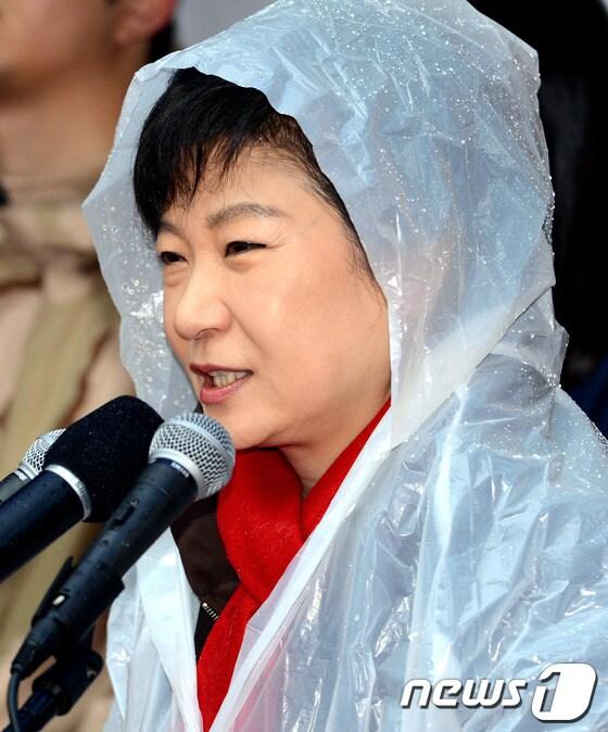 본문 이미지 - 박근혜 새누리당 대통령 후보가 14일 경남 진주시 장대동 진주중앙시장 유세에서 우비를 입은 채 손을 들어 인사하고 있다. 박 후보와 민주통합당 문재인 후보는 대선을 5일 앞둔 이날 격전지인 PK에서 맞불 유세전을 펼친다. 2012.12.14/뉴스1 © News1 이종덕 기자