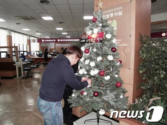 본문 이미지 - 양산시 민원봉사실에 설치된 ‘2013년 새해소망 쪽지 달기 소망트리’에 시민이 소망쪽지를 달고 있다. (양산시 제공)© News1 