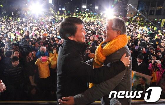 본문 이미지 - 문재인 민주통합당 후보가 15일 저녁 서울 광화문광장에서 유세를 하던 중 예정에 없이 깜짝 등장을 한 안철수 전 후보가 자신에 매고 있던 노란 목도리를 문 후보에게 둘러주고 있다. 2012.12.15/뉴스1 © News1   양동욱 기자