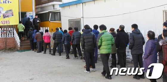 본문 이미지 - 제18대 대통령선거 투표가 일제히 실시된 지난해 12월 19일 광주 북구 삼각동 제3투표소에서 유권자들이 줄을 길게 늘어서 있다. 2012.12.19/ 뉴스1 © News1 김태성 기자