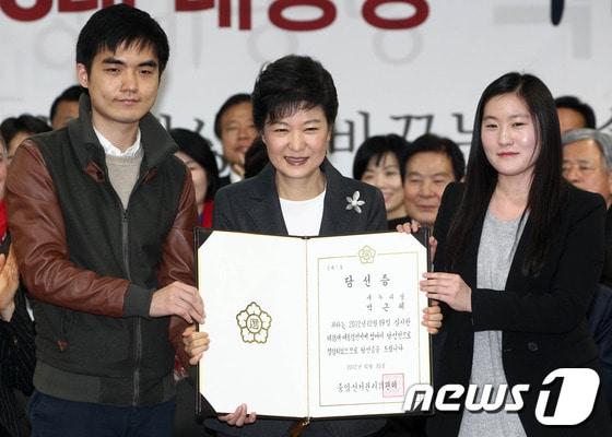 본문 이미지 - 박근혜 대통령 당선인이 19일 서울 여의도 새누리당사에서 열린 중앙선거대책위원회 해단식에서 대학생 대표들에게 당선증을 받고 있다. 2012.12.20/뉴스1 © News1   박정호 기자