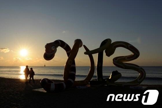 본문 이미지 - 임진년 마지막날인 31일 부산 해운대구 해수욕장에 2013년 계사년을 기념하는 조형물 뒤로 해가 떠오르고 있다. 한국천문연구원이 밝힌 해운대해수욕장의 새해 첫날 해뜨는 시각은 오전 7시 31분이다. 2012.12.31/뉴스1 © News1   전혜원 기자