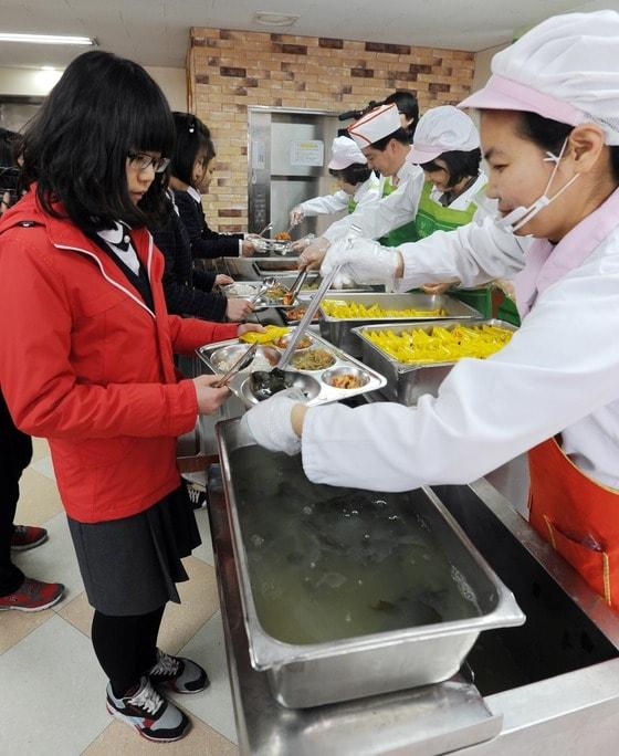 본문 이미지 - 학생들이 학교급식 조리종사원들로부터 배식을 받고  있는 모습 © News1   이정선 인턴기자