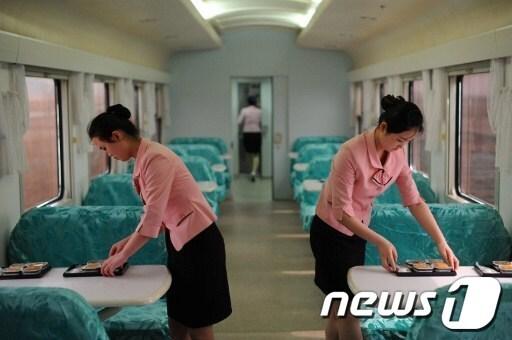 본문 이미지 - 8일 북한 특별열차 안에서 외신기자들을 위한 식사를 준비하는 승무원들 ⓒ AFP=News1