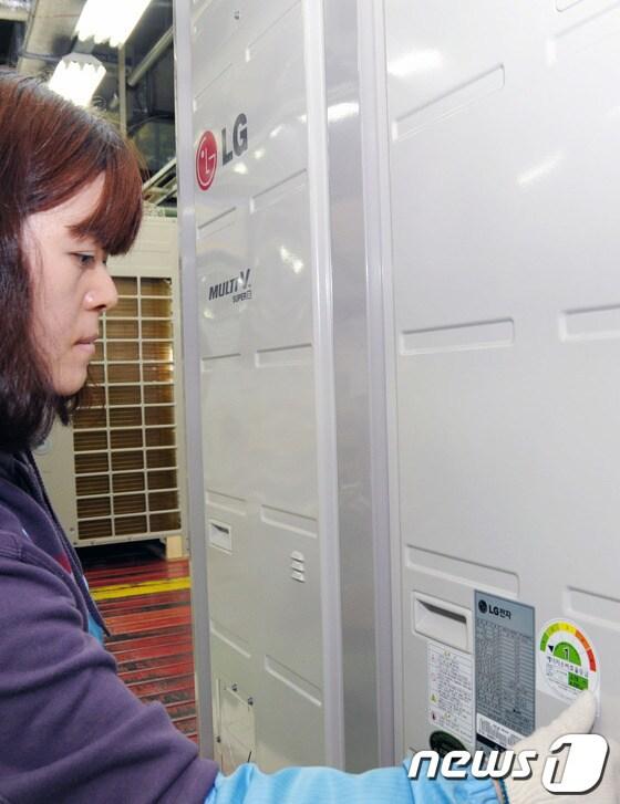 본문 이미지 - LG전자 직원이 창원 생산 공장에서 시스템에어컨 '멀티브이'에 에너지소비효율 1등급 라벨을 부착하고 있다.  © News1 