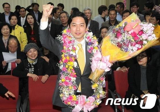 본문 이미지 - 서울 중구 정호준 민주통합당 후보가 서울 신당동 선거사무소에서 사실상 당선이 확정되자 지지자들에게 꽃다발을 받으며 기뻐하고 있다. © News1 