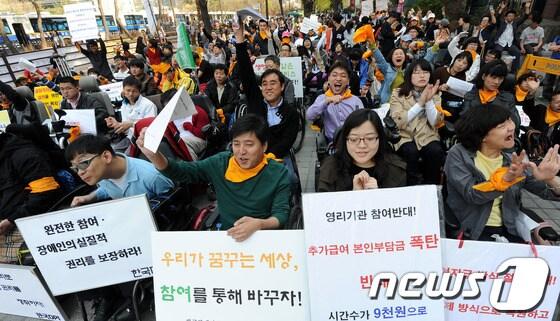 본문 이미지 - 장애인의 날을 하루 앞둔 19일 오후 서울 여의도 이룸센터 앞에서 열린 '장애인총연합, 420장애인대회'에서 참가자들이 구호를 외치고 있다. © News1 박지혜 인턴기자