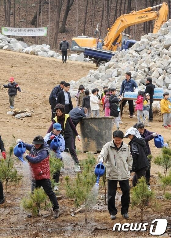 본문 이미지 - 식목일을 사흘 앞둔 2일 오전 서울 서초구 우면산 복구현장에서 열린 ‘뿌리깊은 나무 심기’ 행사에 참가한 주민들이 소나무에 물을 주고 있다. © News1   이정선 인턴기자