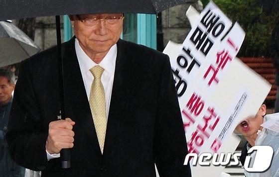 본문 이미지 - 최시중 전 방송통신위원장이 25일 대검찰청에 들어서는 도중 언론노조 조합원들이 기습시위를 벌이고 있다. © News1 한재호 기자