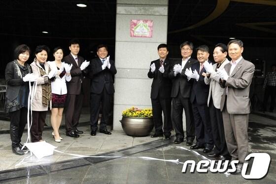 본문 이미지 - 울산 중구와 마제스타워아파트 부녀회는 25일 마제스타워 정문에서 자원봉사 홈타운 행복나눔터 6호점 협약 및 현판식을 가졌다. (사진=울산 중구청 제공) © News1 