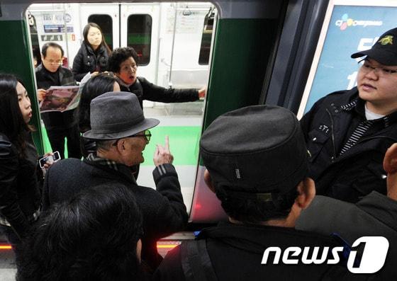 본문 이미지 -  서울 지하철 2호선 운행이 중단된 6일 승객들이 멈춰선 열차 앞에서 역 관계자에게 항의하고 있다.© News1 오대일 기자