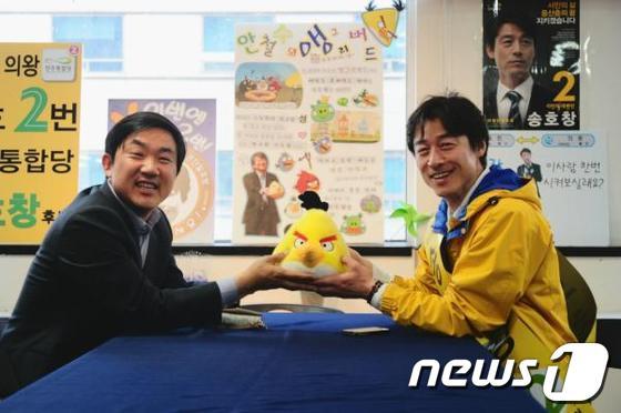 본문 이미지 - 19대 총선 이틀 전인 4월 9일 안철수 서울대 융합과학기술대학원장의 측근인 강인철 변호사가 송호창 민주통합당 후보(경기 의왕과천)를 만나 '앵그리버드' 캐릭터 인형을 건네며 안 원장의 지지 의사를 전하고 있다. (송호창 후보 제공) © News1