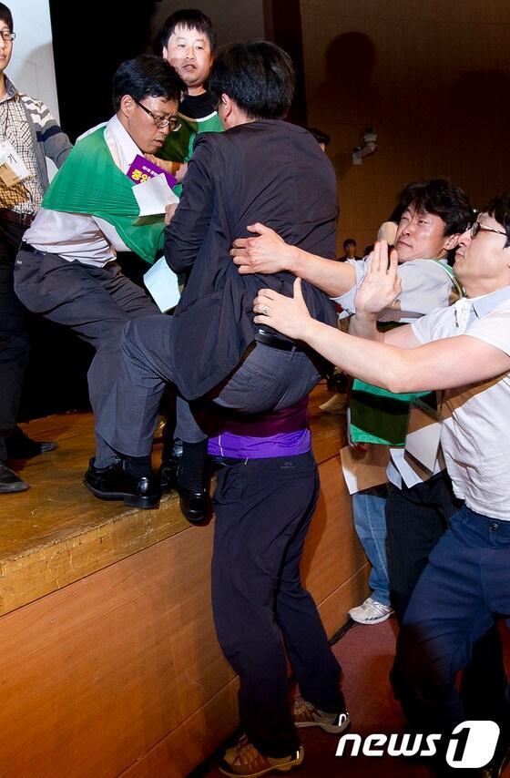 본문 이미지 - 12일 오후 경기 고양 일산 킨텍스에서 열린 통합진보당 2012 제1차 중앙위원회서 통합진보당 당원들과 당권파 중앙위원들이 '불법중앙회 중단'을 외치며 의장석 진입을 시도하고 있다. © News1 이명근 기자