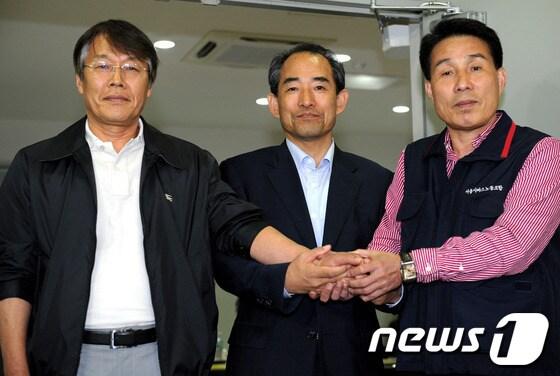 본문 이미지 - 18일 새벽 서울 동자동 서울버스노조회관에서 막판 협상 타결을 이룬 (왼쪽부터) 유한철 서울시버스운송사업조합 이사장, 윤준병 서울시 도시교통본부장, 류근중 서울시버스노조 위원장이 손을 맞잡고 포즈를 취하고 있다. 이날 새벽 3시 박원순 서울시장이 협상장을 전격 방문해 