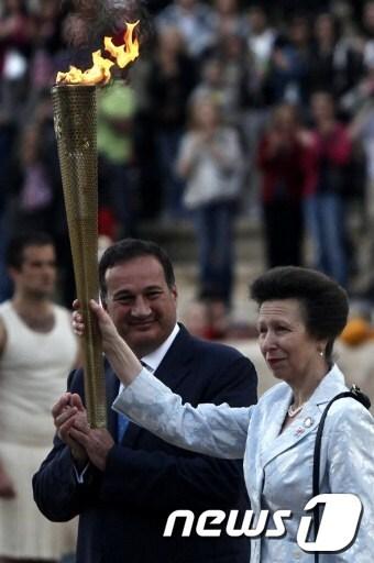 본문 이미지 - 영국 앤공주가 17일(현지시간) 그리스 아테네 올림픽 스타디움에서 열린 성화 전달식에서 런던 올림픽 성화를 건네받고 있다. © AFP=News1 