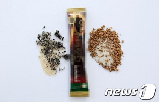 본문 이미지 - 국내 대기업의 커피믹스 봉지에서 상한 것으로 추정되는 커피가 나왔다. 정상제품(오른쪽)과 달리 까맣게 변한 것으로 보이는 커피가 커피믹스 봉지 왼쪽에 놓여져 있다.© News1 김태성 기자 