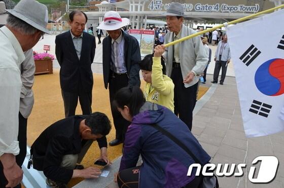 본문 이미지 -  스마트폰 이용해 전시관을 예약하는 장면 © News1/김상렬기자 