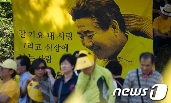 본문 이미지 - 故 노무현 전 대통령 3주기 추모식이 열린 지난 23일 경남 김해 봉하마을에서 추모객들이 노 전 대통령의 생전사진을 보며 추모식장으로 들어서고 있다. 2012.5.23/뉴스1 © News1 이명근 기자