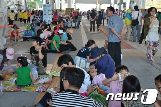 본문 이미지 - 입장객 10만을 넘어선 27일 관람객들이 디지털 갤러리 여기저기에 앉자 보행자들에게 불편을 주고 있다/© News1김살렬기자 