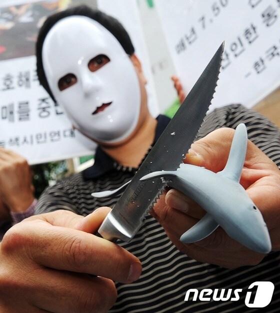 본문 이미지 - 한국동물보호연합과 녹색시민연대 회원들이 지난 5월 서울 소공동 롯데호텔 앞에서 샥스핀(Shark's pin, 상어 지느러미) 요리의 판매 중단을 촉구하는 퍼포먼스를 벌이고 있다. 샥스핀은 상어 지느러미를 떼어낸 뒤 산채로 바다에 버리는 잔혹한 재료 채취 방법이 최근 일반에 알려지면서 미국과 유럽, 아시아 국가들에서 거센 반대 움직임에 직면해 있다. 세계적인 상어보호단체인 '퓨(PEW) 환경그룹'은 