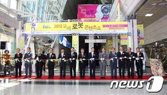 본문 이미지 - 박완수 창원시장&#40;오른쪽 6번째&#41;이 4일 열린 2012년 국제로봇콘텐츠쇼 개막식에 참석해 테이프 커팅을 하고 있다.&#40;창원시 제공&#41; © News1 