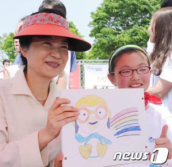 본문 이미지 - 새누리당 박근혜 비상대책위원장이 어린이날인 5일 오전 서울 송파구 방이동 올림픽공원에서 열린 세이브 더 칠드런의 희망책장 만들기에 참석해 어린이와 함께 그린 그림을 들고 있다. 2012.5.5/뉴스1 © News1 양동욱 기자