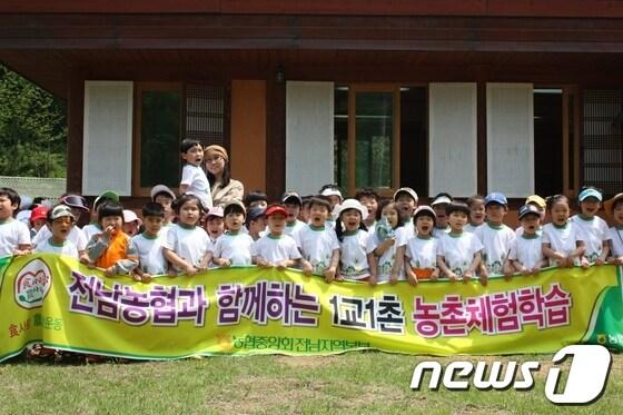 본문 이미지 - 전남농협이 실시한 1교1촌 농촌체험학습에 참가한 학생들이 기념촬영하고 있다./사진제공=전남농협© News1 
