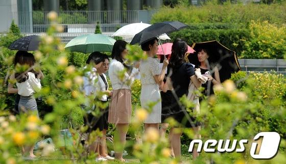 본문 이미지 -  이화여자대학교에서 학생들이 더위를 피하기 위해 양산을 쓰고 있다.  © News1 박지혜 기자