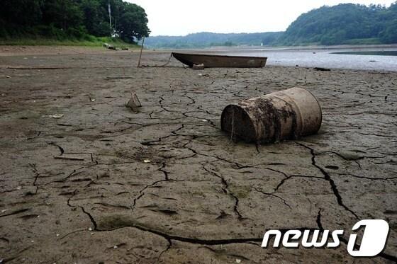 본문 이미지 - 본격적인 농번기가 시작됐지만 5월 이후 극심한 가뭄이 이어지고 있는 13일 경기 파주시 조리읍 공릉저수지 저수율이 30% 이하로 떨어진 가운데 나룻배 한 척이 갈라진 바닥에 덩그러니 놓여 있다.  2012.6.13/뉴스1 © News1 한재호 기자