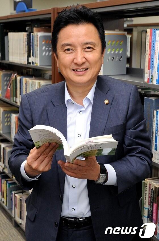 본문 이미지 - 민주통합당 김영환 의원. 국회 도서관에서 뉴스1과 인터뷰에서 책을 들고 촬영에 응하고 있다.2012.6.18/뉴스1 © News1   이종덕 기자