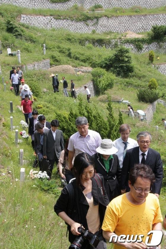 본문 이미지 - 민주통합당 문재인 고문과 참배객들이 6일 경북 칠곡군 동명면 학명공원을 찾았다.. 문 고문과 참배객들이 지난 1996년 세상을 떠난 일본군위안부 고 문옥주 할머니 묘소를 참배하기 위해 줄지어 가고 있다. © News1 김대벽 기자