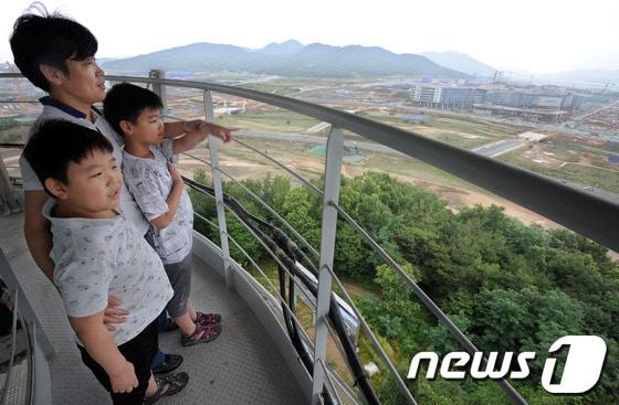본문 이미지 - 세종특별자치시가 공식 출범했던 지난해 7월1일 충남 연기군 밀마루전망대를 찾은 시민들이 막바지 공사로 분주한 세종시일대를 바라보고 있다.  (자료사진) © News1 