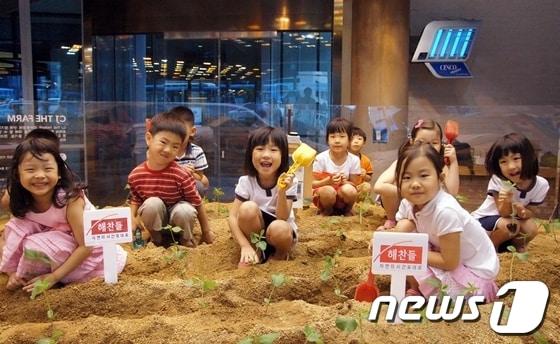 본문 이미지 - 지난 6월 28일 CJ식품연구소 'CJ The Farm'에서 열린 '자연의 시간표대로' 체험행사에 참여한 어린이들이 콩을 심고 있다. © News1 