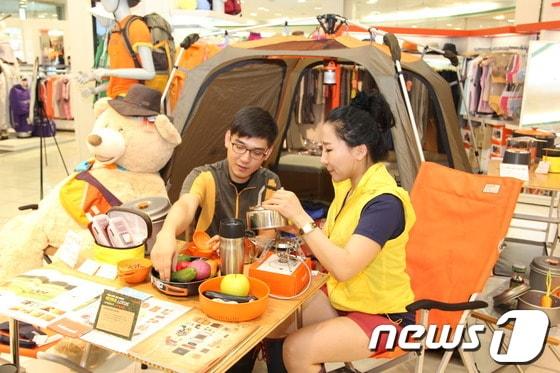 본문 이미지 - p캠핑 인구 120만명 시대를 맞아 캠핑 잠자리가 진화하고 있다. 사진은 갤러리아백화점 타임월드점이 캠핑용품 할인 판매행사를 하는 모습./p