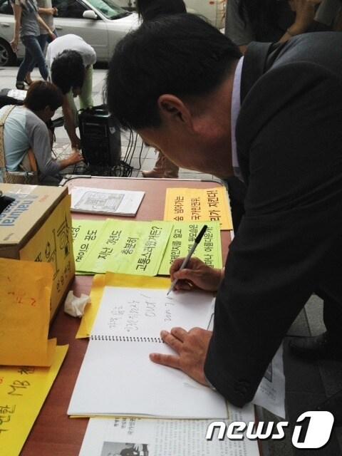 본문 이미지 - 부좌현 민주통합당 소속 현병철 후보자 인사청문회 위원이 13일 오후1시 현병철 인권위원장 연임반대와 국가인원귀 바로세우기 전국 긴급행동의 천막 자진철거 기자회견에 참석해 방명록에 글을 남기고 있다. © News1 