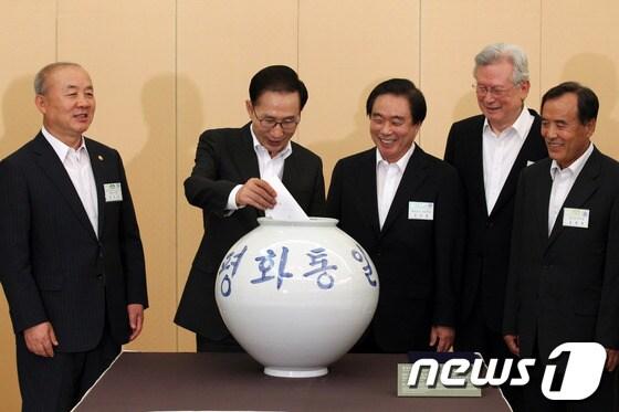 본문 이미지 - 이명박 대통령이 16일 오후 청와대에서 '평화통일'이라고 쓰인 항아리에 금일봉을 기부하고 있다. (청와대 제공) 2012.7.17/뉴스1