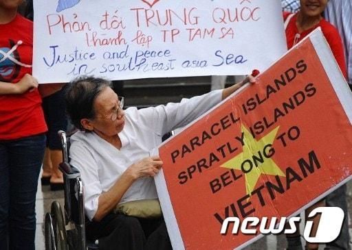 본문 이미지 - 베트남 하노이에서 시위대가 파라셀제도와 스프래틀리군도는 베트남의 영해라는 내용의 플래카드를 들고 반중국 시위를 벌이고 있다. ⓒ AFP=News1