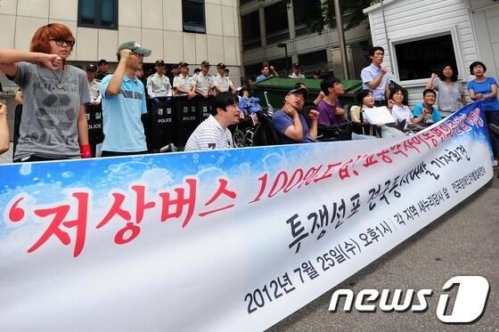 본문 이미지 - 전국장애인차별철폐연대 회원들이 지난해 새누리당사 앞에서 &#39;저상버스 100%도입! 교통약자이동편의증진법 개정 요구&#39; 기자회견을 열고  있다. © News1 손형주 인턴기자