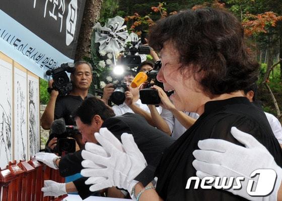 본문 이미지 - 27일 오전 서울 서초구 우면산 산사태 현장에서 열린 '우면산 산사태 1주기 추모식'에서 한 유가족이 헌화하며 오열하고 있다. 2012.7.27/뉴스1 © News1   허경 기자