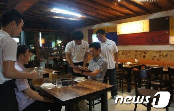 본문 이미지 - 대덕대 호텔관광과 이현재 교수(오른쪽에 앉은 이)가 ‘갈비 더’에서 산학협력 활동에 참여하는 학생들을 찾아가 지도하고 있다. © News1 